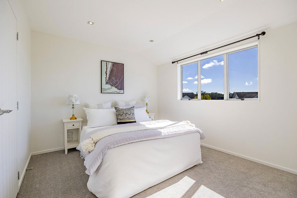 Spacious master bedroom in affordable Albany home with wide windows, carpeted floors, and serene suburban outlook – located in a family-friendly cul-de-sac.