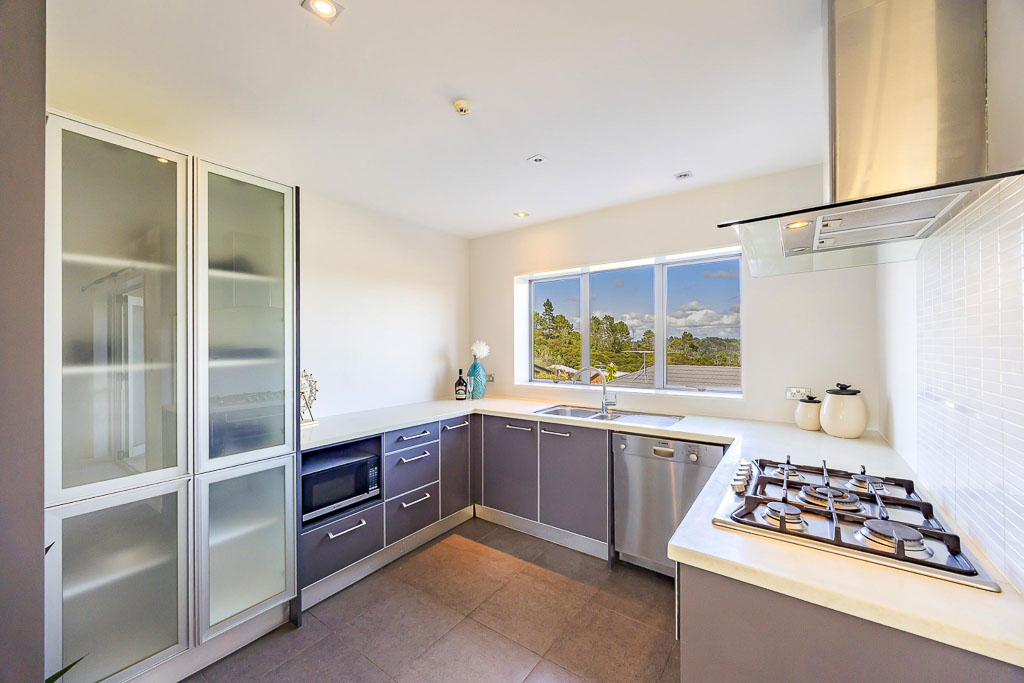 Stylish kitchen in affordable Albany townhouse showcasing generous pantry storage, tiled splashback, and contemporary fittings.