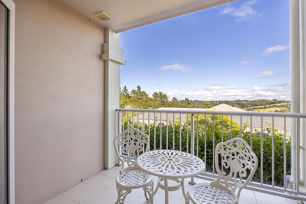 Elevated balcony in Albany Heights home featuring a white cast iron outdoor dining set and panoramic views of the North Shore – ideal for relaxed morning coffee or evening sunsets.