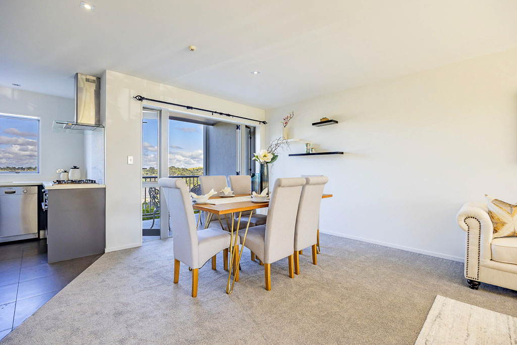 Open-plan dining and lounge in Albany Heights real estate, filled with natural light and seamless indoor-outdoor flow – ideal for entertaining.