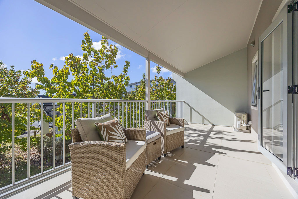 Expansive covered balcony in Albany real estate listing offering privacy, greenery views, and comfortable lounge seating – perfect outdoor living space in a peaceful cul-de-sac.