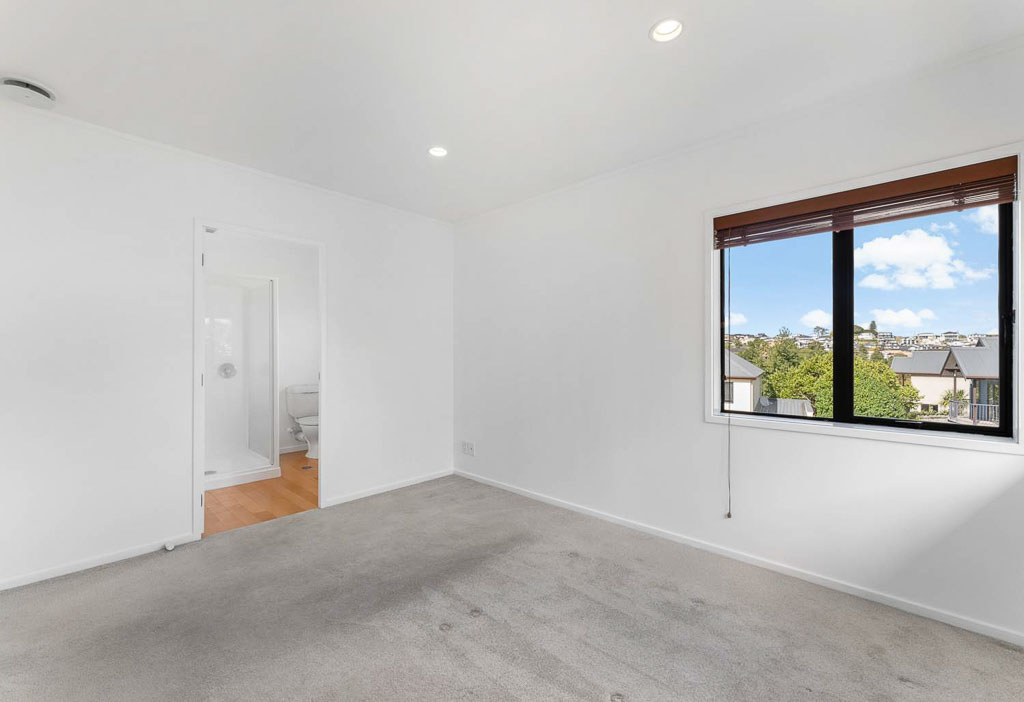 North-facing bedroom at 9/12-20 Northcross Drive, Albany townhouse with double wardrobe, plush carpet, and scenic suburban views – real estate in top school zone.