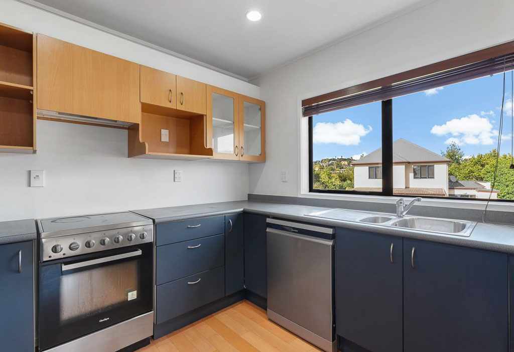 Modern Albany townhouse kitchen with stainless steel appliances, large window, and ample cabinetry – perfect for first home buyers.