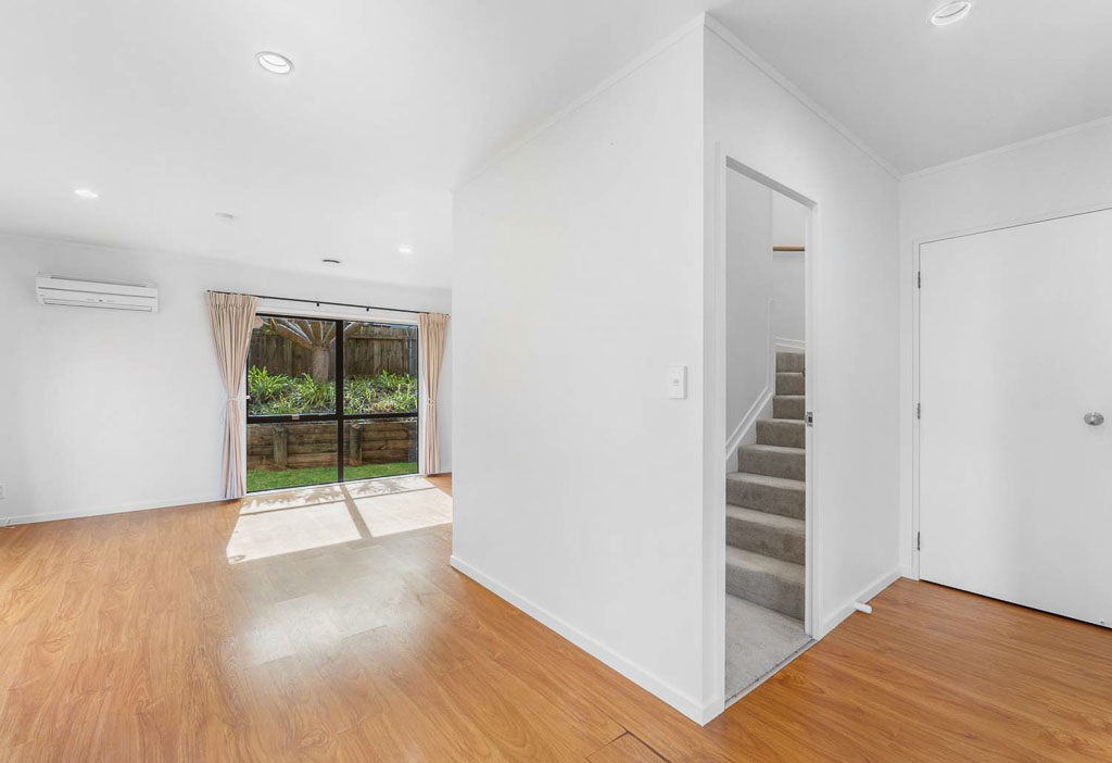 Ground floor living space in Albany townhouse with direct outdoor access, natural light, and internal staircase – smart North Shore real estate.