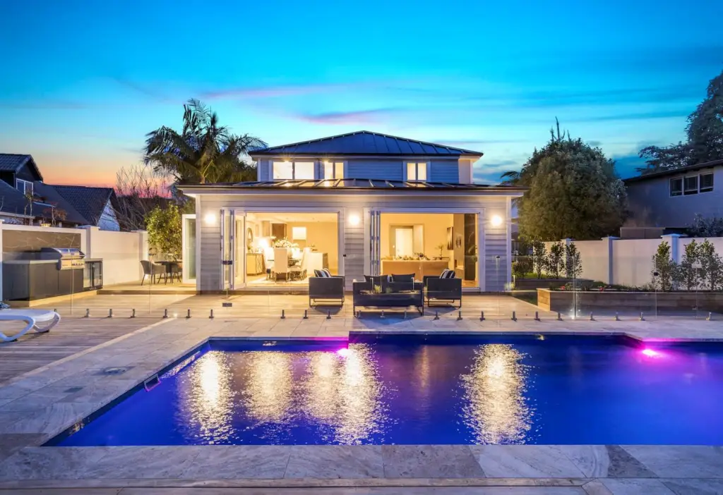 Luxury Albany home with illuminated swimming pool at sunset, marketed by Real Estate Agent in Albany Michael Hossaini, Barfoot & Thompson.