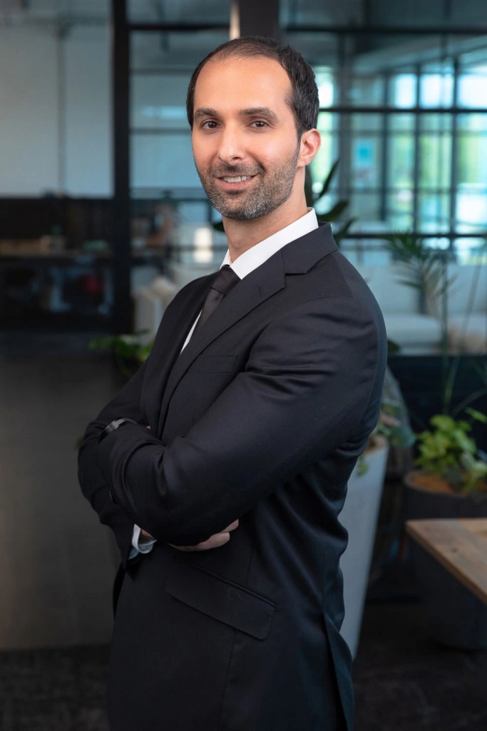 Experienced real estate agent in North Shore confidently standing in a professional setting.