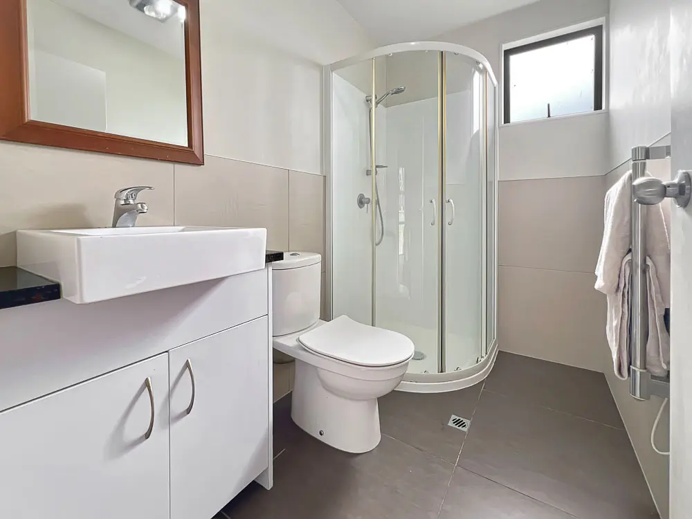 Modern family bathroom with corner shower and vanity – 12E Schnapper Rock Road.