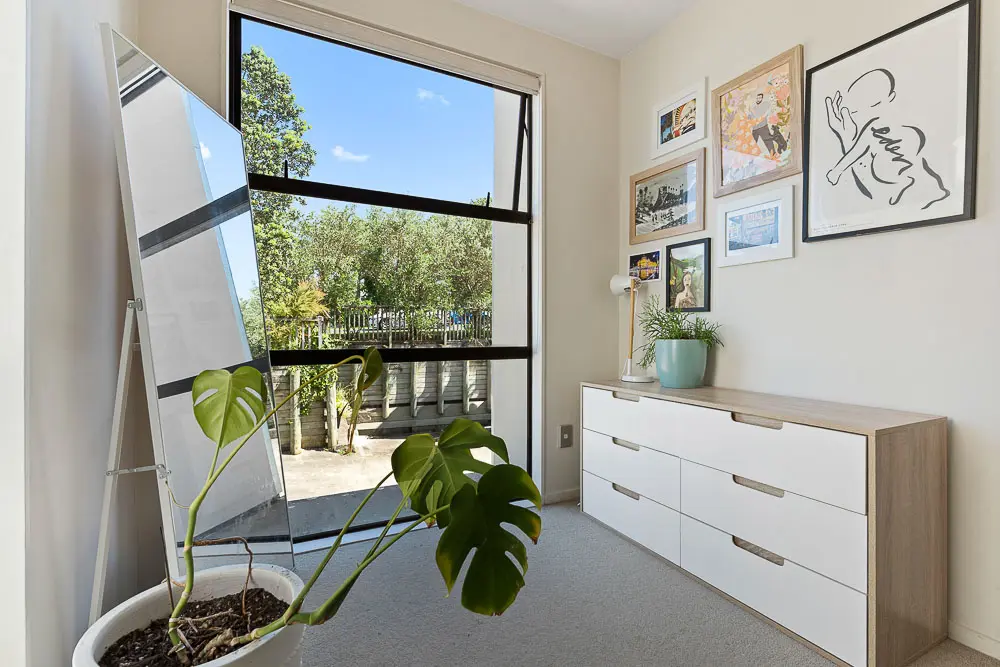 Bright upper-level nook with dresser, large windows, and framed artwork.